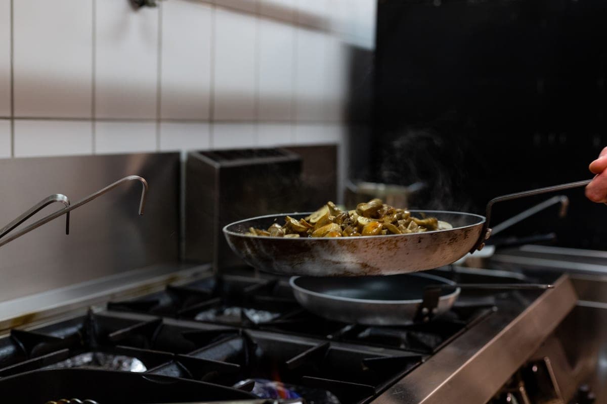 Dark carbon steel frying pan with a long steel handle